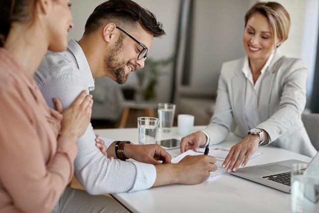 Couples signing insurance happily together